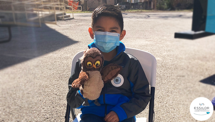 Daniel sitting outside the Kids Vision for Life mobile clinic with his puppet owl